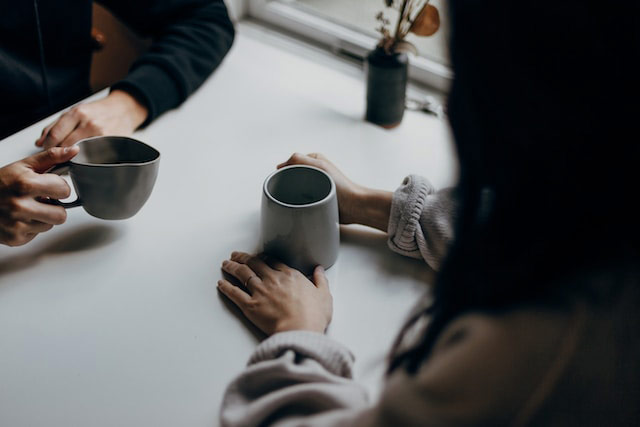 table with two people drinking coffee together